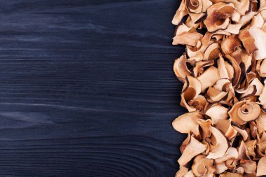 Yenilebilir kurutulmuş mantarlar siyah ahşap zemin kaplama üst görünüm, kuru boletus edulis koyu ahşap zemin çerçeve, kahverengi başlık boletus, bozuk para çöreği, cep, porcino, porcini, beyaz mantar, metin kopyalama alanı