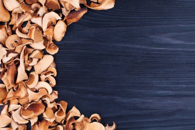 Yenilebilir kurutulmuş mantarlar siyah ahşap zemin kaplama üst görünüm, kuru boletus edulis koyu ahşap zemin çerçeve, kahverengi başlık boletus, bozuk para çöreği, cep, porcino, porcini, beyaz mantar, metin kopyalama alanı