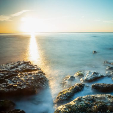 Gün doğumunda Pett Level 'de uzun süre maruz kalma dalgalar kayaların üzerinden ilerlerken.