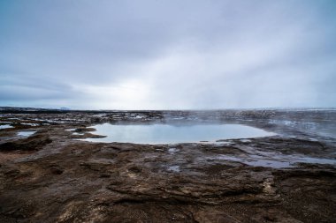 İzlanda 'da bir gayzer. Buharı yavaşça yüzeyine yayılıyor.