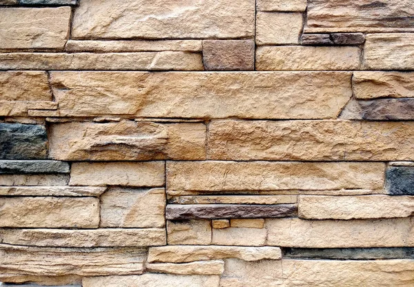 Texture d'un mur de briques avec des briques de différentes formes tailles et épaisseurs ainsi que des couleurs. le mur d'un bâtiment moderne est brun clair avec du café et des briques gris foncé pour l'arrière-plan — Photo