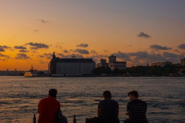 Deniz kenarında oturan insanlar