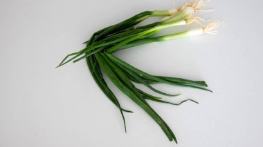 Beyaz arkaplanda yeşil soğan