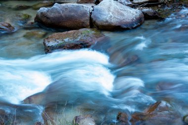 Donmuş çimenler arasında akan akarsu