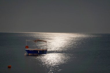 Ay ışığında deniz manzarası ve tekneler