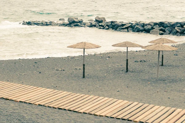 Kumsalda çizgili şemsiyeler