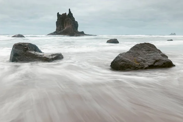 Пляж Бенихо с ориентиром на заднем плане и двумя скалами на переднем плане — стоковое фото