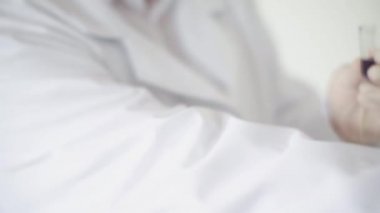 Deneysel maddenin kırmızı ile eklendiği test tüpü. Sondanın içindeki sıvı elle kapatılmış. Test tüpündeki sıvı elle çatlamış.
