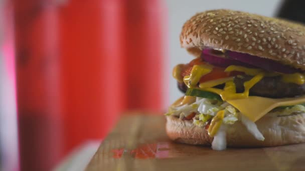 Hamburguesa deliciosa fresca. close-up.hands en guantes negros tomar una hamburguesa de la mesa antes de comer — Vídeos de Stock