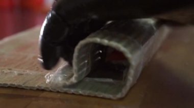 Kapat. Suşi hazırlar, mutfakta rulo ekmek hazırlarız. Pirinç ve somon balığını normlara sarar. Balık kullanır.