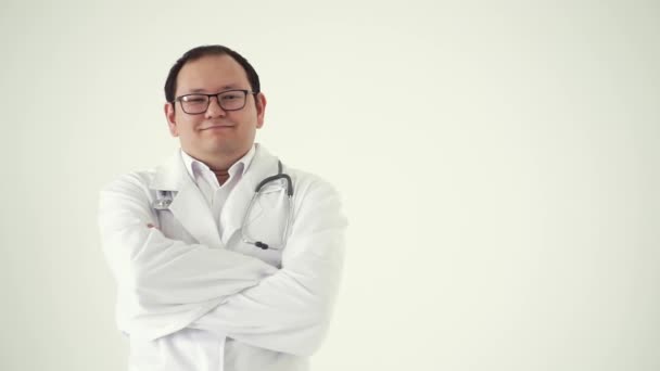 Feliz médico asiático brazos cruzados aislados sobre fondo blanco.Concepto de profesión, medicina y salud, educación médica.Terapeuta masculino dobla los brazos delante de sí mismo, de pie en una rehabilitación — Vídeos de Stock