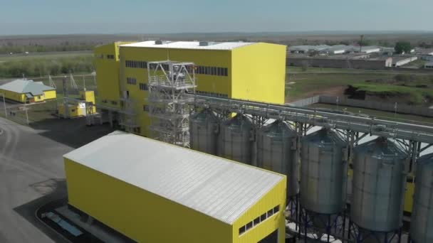 Granero agrícola para almacenamiento en tanques. Instalaciones de producción en la planta. Edificios amarillos y elevadores de granos — Vídeo de stock