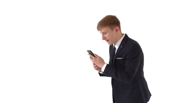 Portret van een gelukkige zakenman die een bericht op zijn telefoon leest en een overwinning viert. Een verrassende knappe man wint op de wedlijn. Schreeuw hardop. — Stockvideo