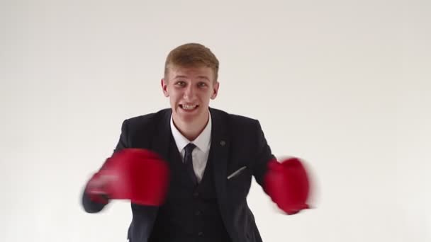 An angry, aggressive businessman with boxing gloves says that you cannot challenge him in boxing or in business. Workplace stress resistance concept, office worker — Stock Video