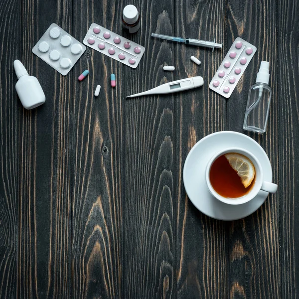 Çayın üst görüntüsü, termometre ve tahta arka planda haplar.. 