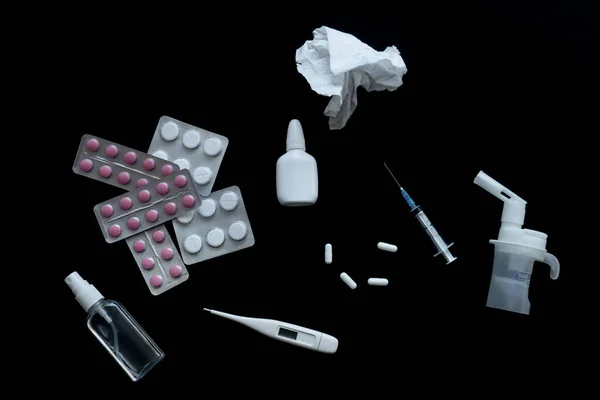 Ovanifrån av piller, termometer och nässpray på svart bakgrund — Stockfoto