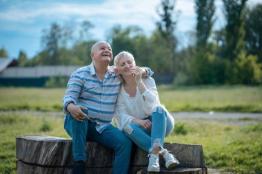 Mutlu son sınıf çifti güneşli bir günde parkta çıkıyor, sarılıyor ve konuşuyor.