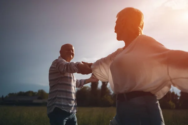 Mutlu son sınıf çifti romantik bir şekilde buluşur ve güneşli havada dans eder.