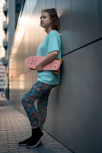 Güzel genç kız güneşli bir günde sokakta elinde bozuk para tahtasıyla dikiliyor.