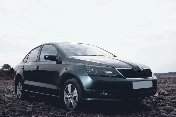 Kayalık nehir arazisinde siyah sedan spor araba..