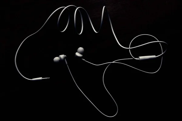 Earphone. White earphone with dark background .