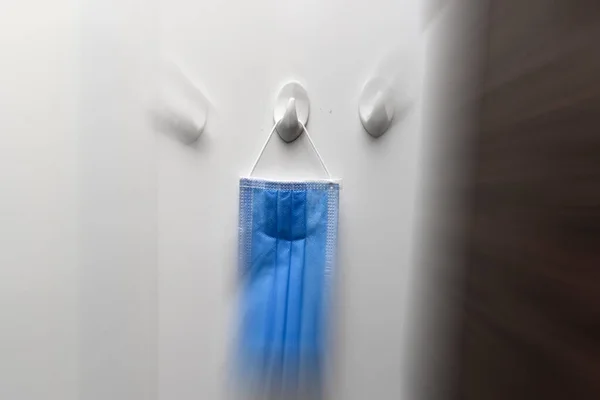 Mavi tıbbi maske, hareket bulanıklığı olan bir askıda asılı. Yeni yaşam tarzı kavramı .