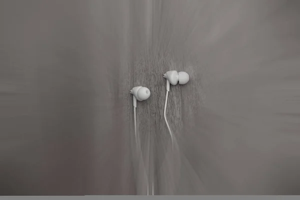 Tahta arka planda izole edilmiş hareket bulanıklığı olan beyaz kulaklık..