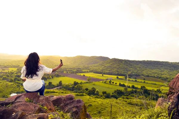 Kız dağ kayasının tepesinde selfie çekiyor..