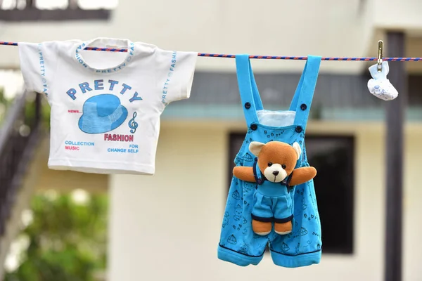Çamaşır ipine asılı bebek kıyafetleri. Açık hava kavramı .