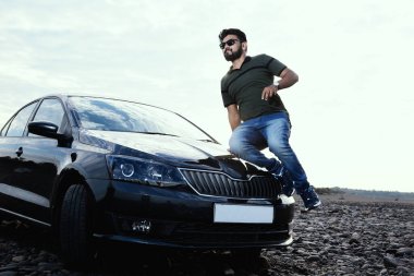 Şık bir adam arabanın kaputunun üzerinden atladı. .