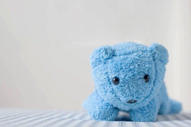 Sevimli küçük oyuncak ayı yatağa uzanıyor..