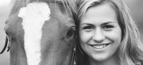 the head of a woman to the head of a horse. Young woman smiling.