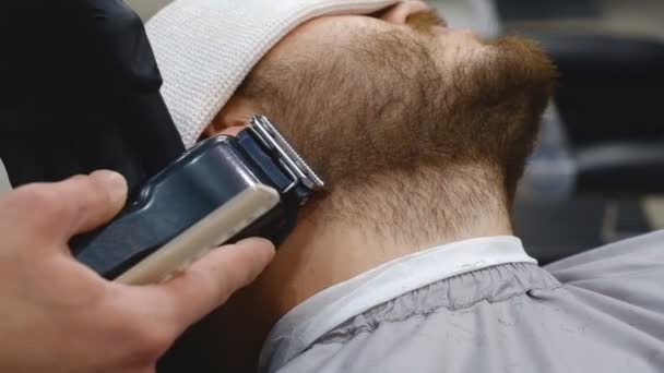 Профессиональная стрижка и бритье бороды в парикмахерской — стоковое видео
