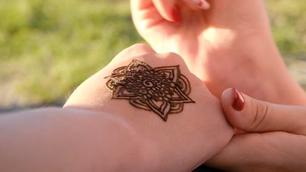 Frau zeichnet Henna auf ihre Hand im Freien — Stockvideo
