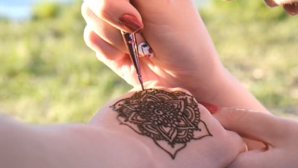 Mulher desenha henna em sua mão ao ar livre — Vídeo de Stock