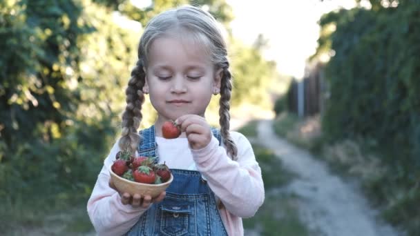 Niña comiendo fresas en el parque de verano — Vídeos de Stock