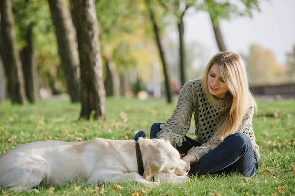 Vacker Blondin Sitter Gräset Parken Och Leka Med Hennes Hund — Stockfoto