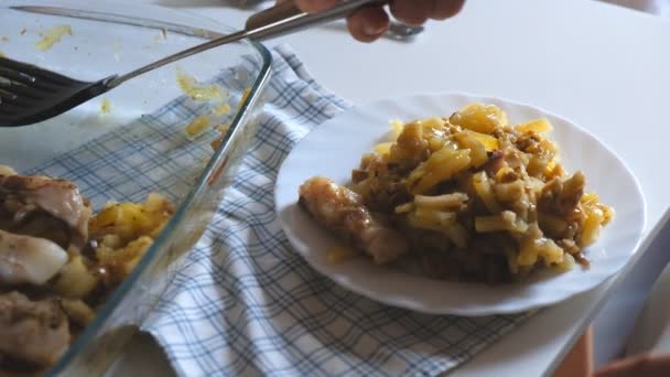 A woman puts food on a plate with a shovel. — Stock Video