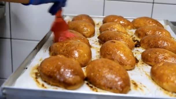 Der Konditor schmiert die fertigen Kuchen mit süßem Sirup. — Stockvideo