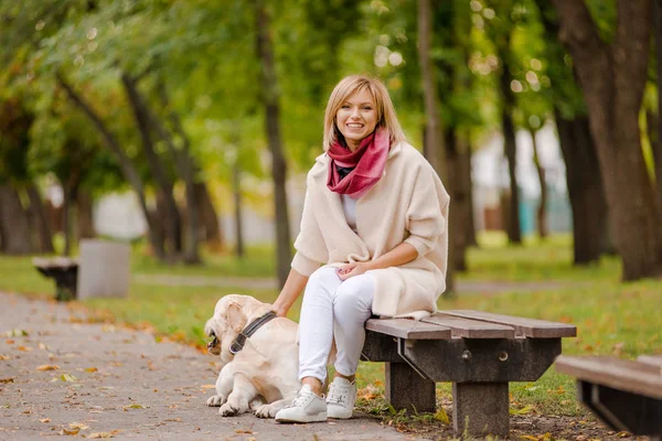Ung Kvinna Sitter Bänk Parken Och Hennes Labrador Promenader Närheten — Stockfoto