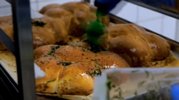 Ο σεφ ζαχαροπλαστικής καθορίζει φρέσκα αρτοσκευάσματα στην βιτρίνα στο αρτοποιείο. — Αρχείο Βίντεο