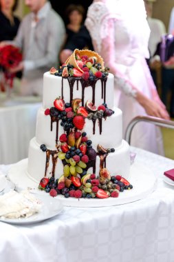 Düğün masa üzerinde duruyor meyve ile büyük pasta düğün beyaz.