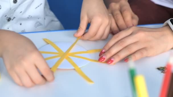 The boy glues the sun on a creative lesson in school. — Stock Video