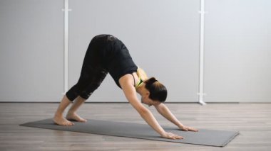 Genç kadın spor salonunda yoga yapıyor. Yogi asanas gerçekleştirir.