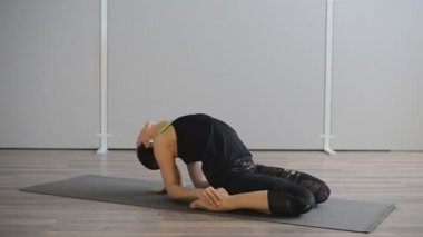 Genç kadın spor salonunda yoga yapıyor. Yogi asanas gerçekleştirir.