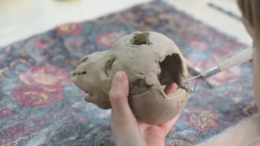 Çocuk seramik atölyede farklı türde kil ürünleri şekillendirmeyi öğreniyor. Çocuk, yaratıcı bir derste kilden bağımsız olarak çalışır..