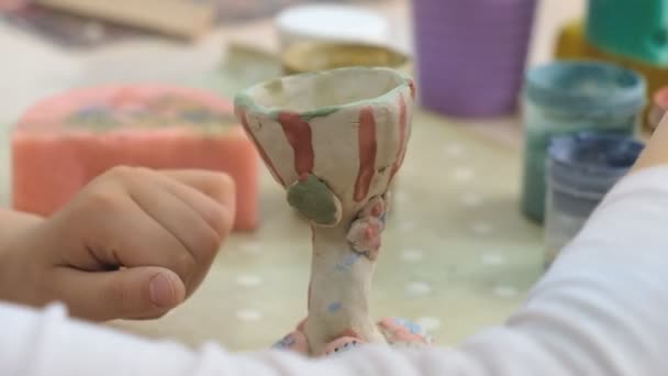 子供はセラミックワークショップで異なる種類の粘土製品を成形することを学びます 子供は創造的なレッスンで粘土と独立して動作します — ストック動画