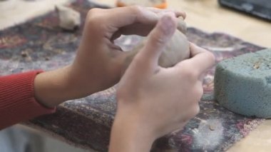 Çocuk seramik atölyede farklı türde kil ürünleri şekillendirmeyi öğreniyor..