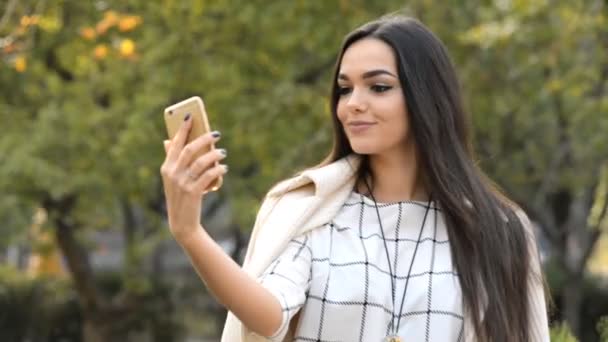 Mladá krásná bruneta obchodní lady takže selfie v parku. — Stock video