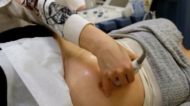 Hamile bir kadın doktor ultrason yapıyor..